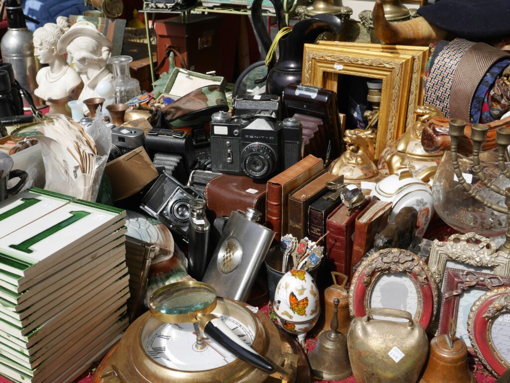 Person decluttering a cluttered space with black and silver stereo components, representing the process to declutter your life and create a more organized environment.