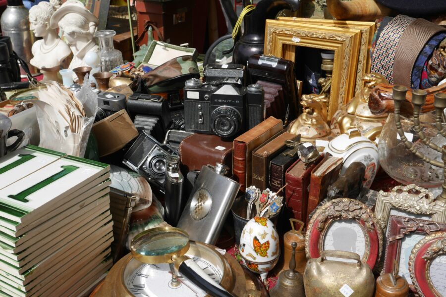 Person decluttering a cluttered space with black and silver stereo components, representing the process to declutter your life and create a more organized environment.