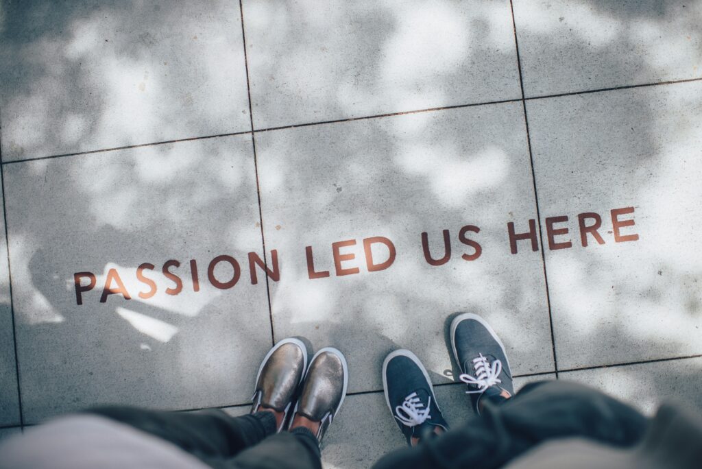 Overhead view of two people standing on a tiled pavement with the words 'Passion Led Us Here,' reflecting the journey of strengthening their relationship with God through commitment, prayer, and trust.