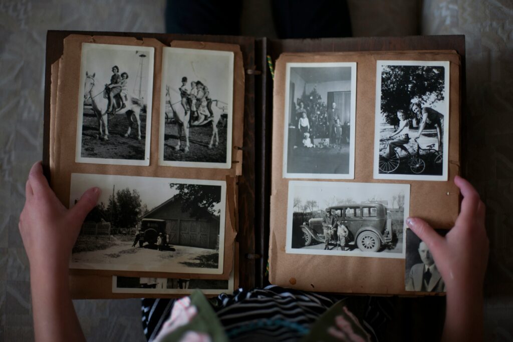 An open photo album filled with black-and-white family photographs, showcasing cherished memories and moments passed down through generations, representing the idea of leaving a meaningful legacy.