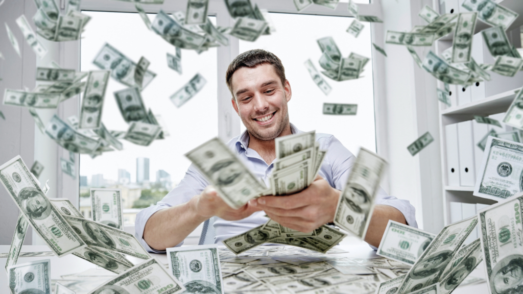 A happy businessman sitting at a desk, surrounded by flying U.S. dollar bills, joyfully counting his money in a bright office with a cityscape view in the background.