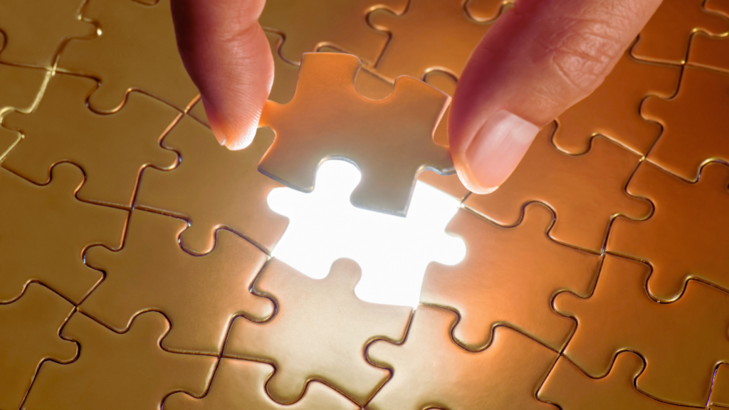 A hand placing the final puzzle piece into a glowing puzzle, symbolizing the resolution of problems.